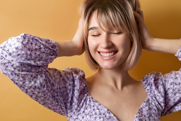 Foto gratuita mujer posando con fondo amarillo de cerca