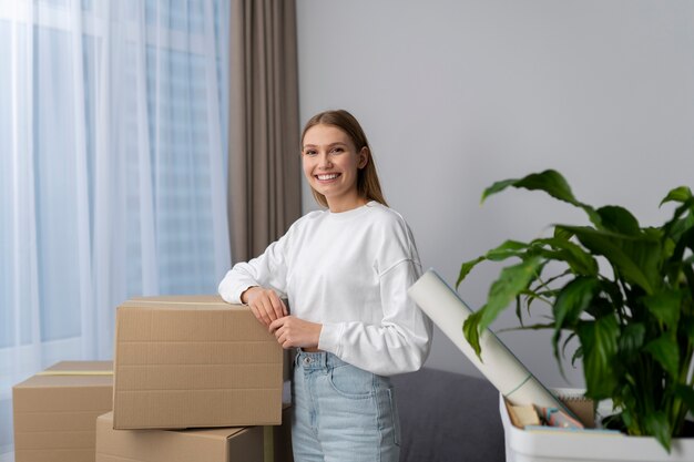 Mujer posando junto a cajas de pertenencias