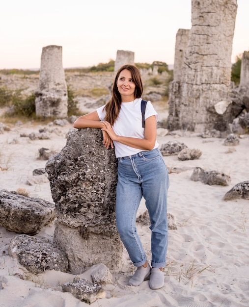 Mujer posando junto a una roca