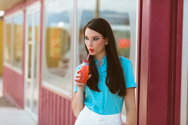 Mujer posando juntos en estilo retro con bebida