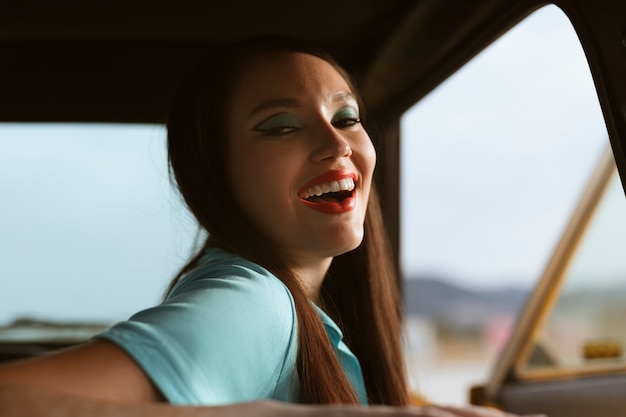 Mujer posando juntos en estilo retro dentro del coche