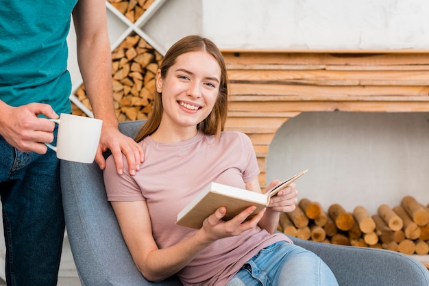 Mujer posando con libro y sonriendo