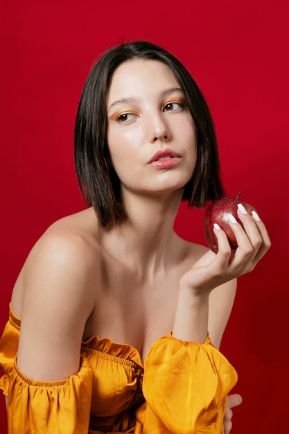 Mujer posando manzana en mano