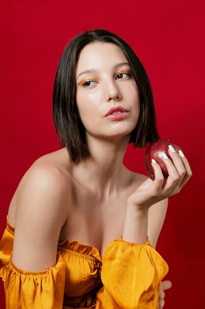 Mujer posando manzana en mano