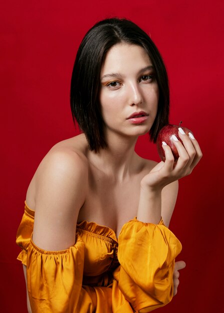 Mujer posando con manzana en mano