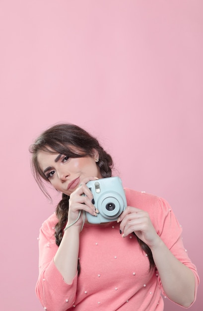 Mujer posando mientras sostiene la cámara con espacio de copia