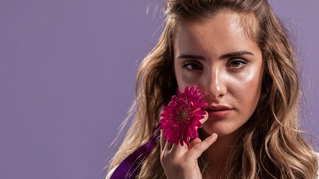 Mujer posando mientras sostiene un crisantemo con espacio de copia