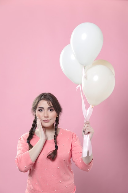 Mujer posando mientras sostiene globos