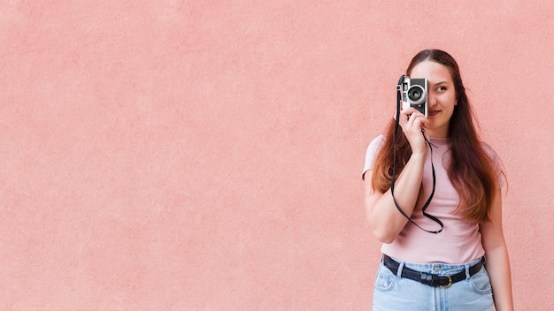 Mujer posando mientras toma una foto con la cámara