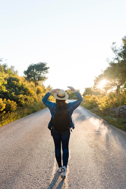 Foto gratuita mujer posando con mochila en medio del camino