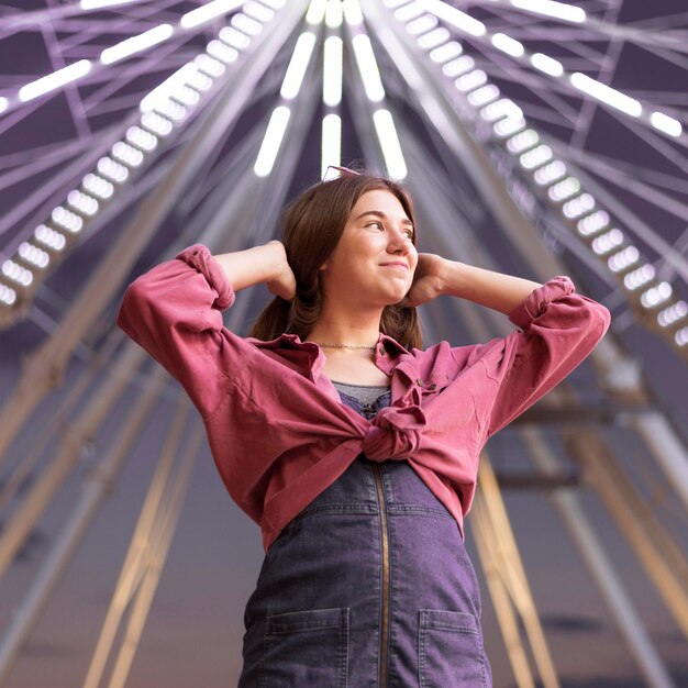 Mujer posando en el parque de atracciones junto a la noria