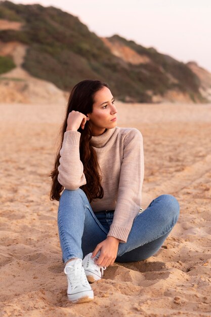 Mujer posando en la playa de arena