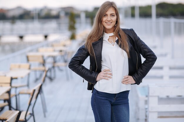 Mujer posando en un restaurante en un puerto marítimo