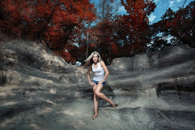 Mujer posando en unas rocas en un bosque