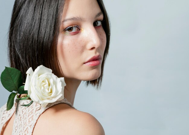 Mujer posando con rosa blanca