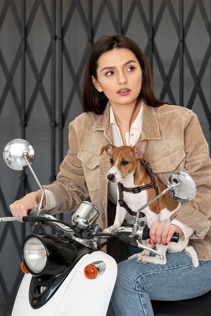 Mujer posando en scooter con su perro