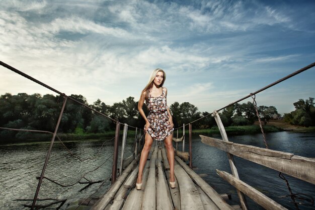 Mujer posando sobre un puente de madera