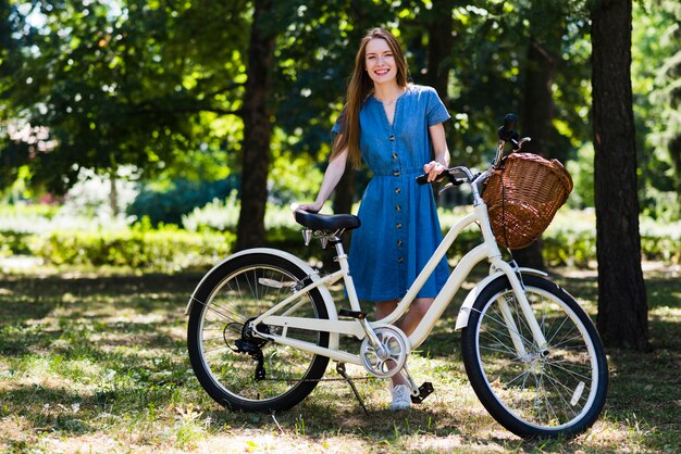 Mujer, posar, al lado de, bicicleta