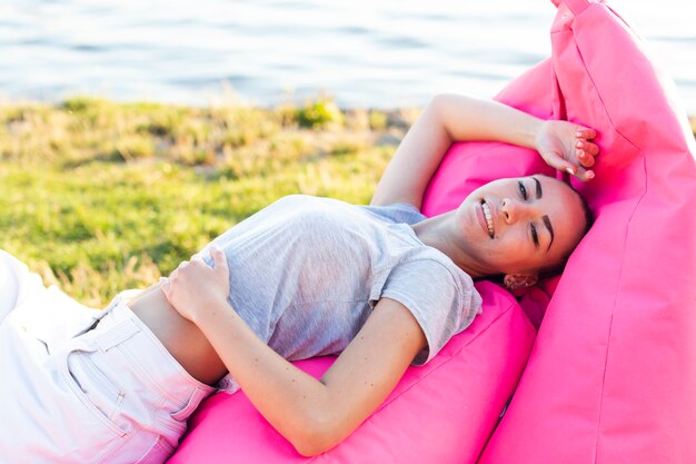 Mujer, posar, en, rosa, beanbag