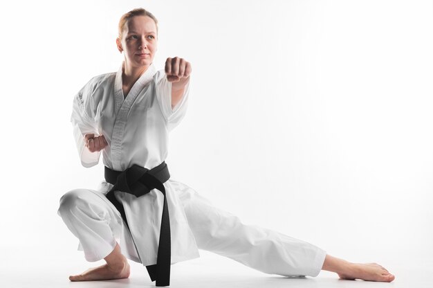 Mujer en pose de karate tiro completo