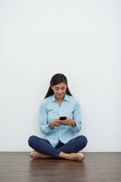 Mujer en posición de loto con smartphone