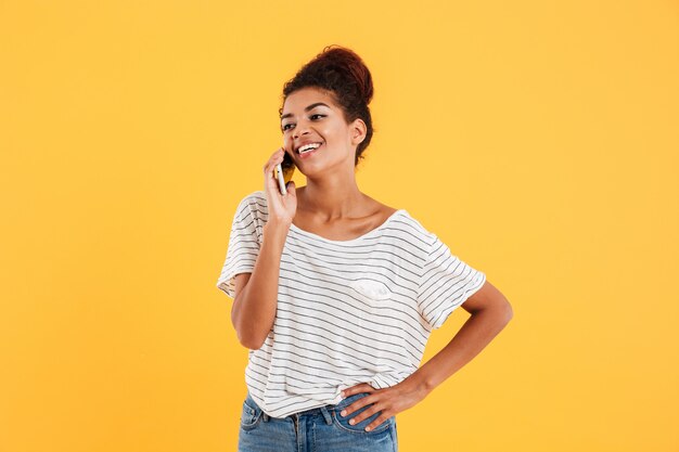 Mujer positiva alegre que habla en el teléfono aislado