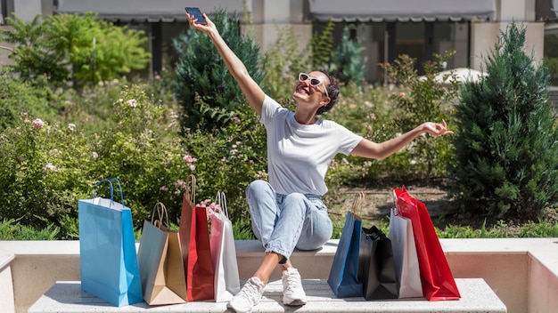 Mujer positiva celebrando bolsas de la compra.