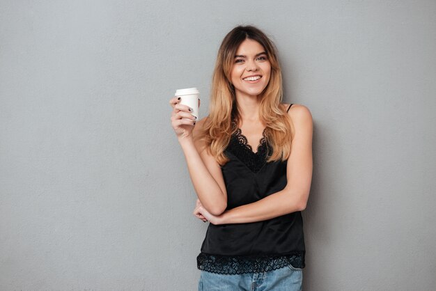 Mujer positiva que sostiene la taza de café