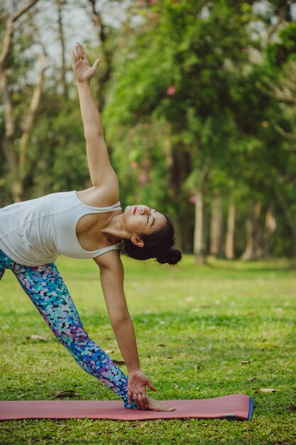 Mujer en postura de yoga en el parque
