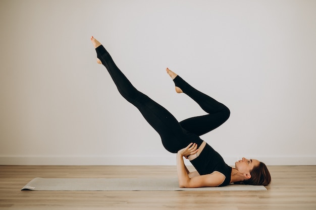 Mujer practica pilates en el gimnasio de yoga