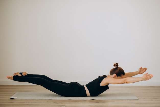 Mujer practica pilates en el gimnasio de yoga