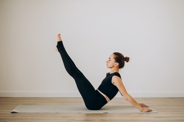 Mujer practica pilates en el gimnasio de yoga