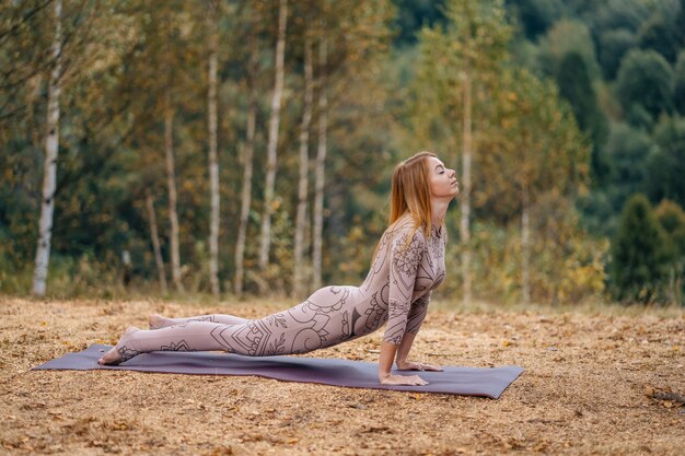 Una mujer practica yoga en la mañana en un parque al aire libre.