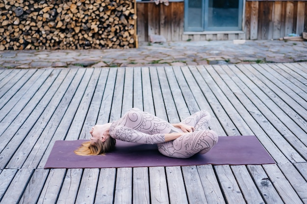 Foto gratuita una mujer practica yoga por la mañana en una terraza al aire libre.