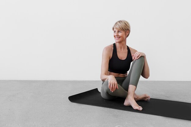 Mujer practicando deporte en estera de yoga