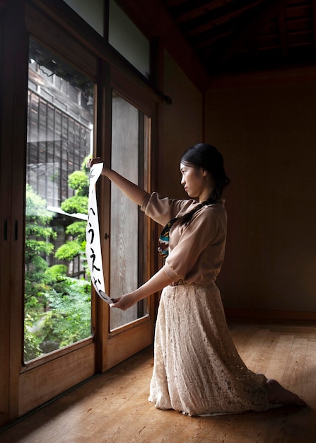 Foto gratuita mujer practicando la escritura japonesa en casa