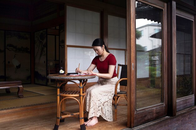 Mujer practicando escritura japonesa en interiores