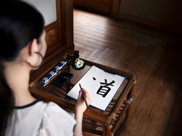 Mujer practicando escritura japonesa