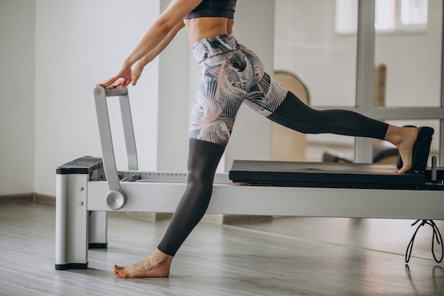 Mujer practicando pilates en una pilates reformer piernas de cerca