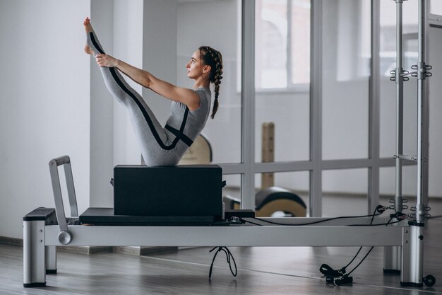 Mujer practicando pilates en un reformador de pilates