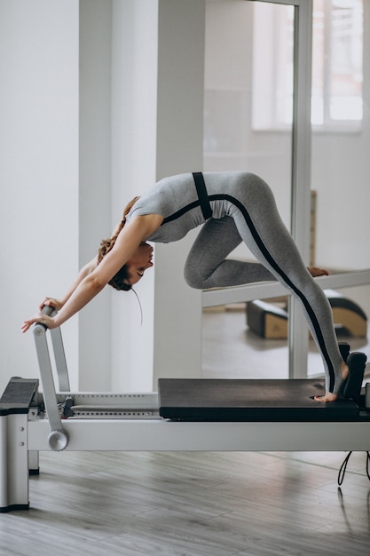 Mujer practicando pilates en un reformador de pilates