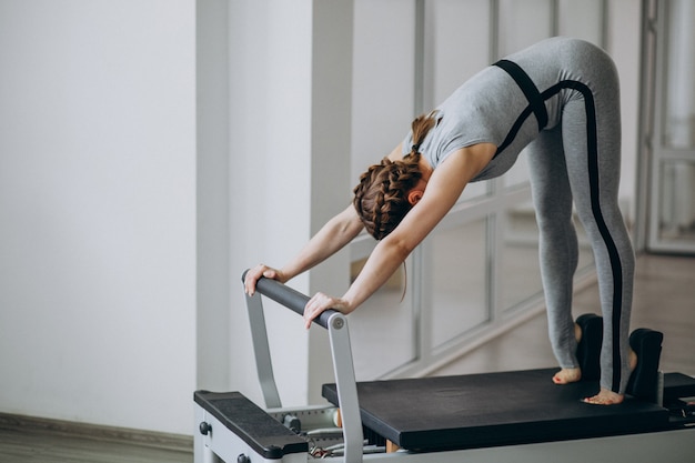 Mujer practicando pilates en un reformador de pilates