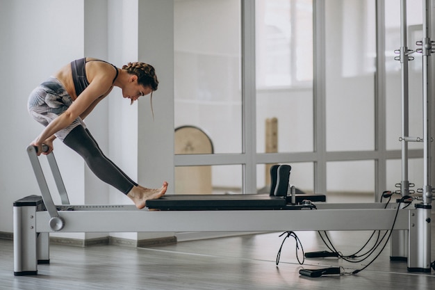 Mujer practicando pilates en un reformador de pilates