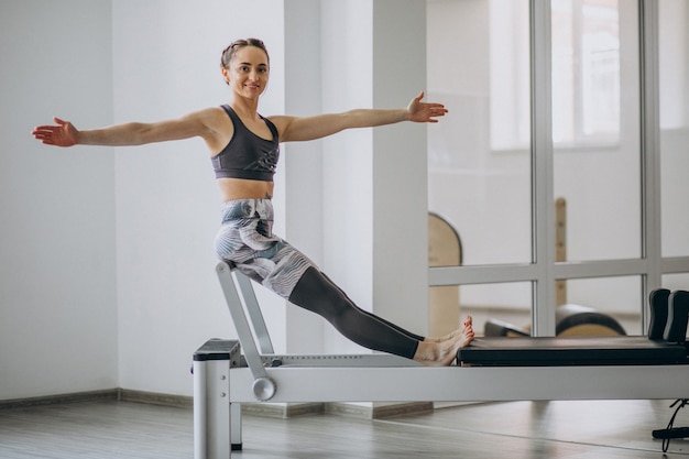 Mujer practicando pilates en un reformador de pilates