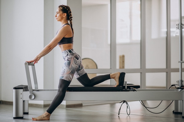 Mujer practicando pilates en un reformador de pilates