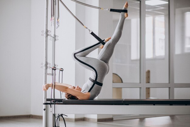 Mujer practicando pilates en un reformador de pilates