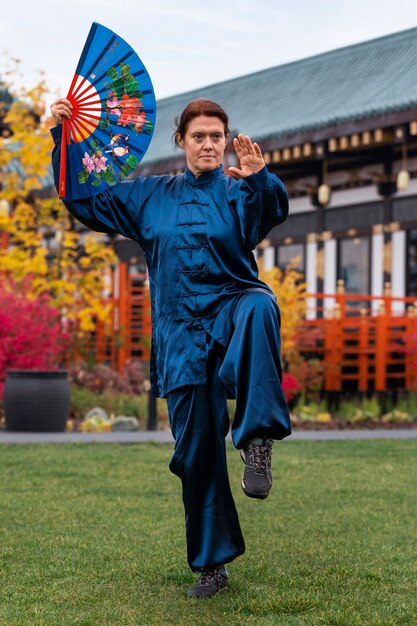 Mujer practicando tai chi al aire libre tiro completo