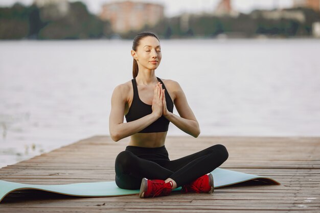 Mujer practicando yoga avanzado por el agua