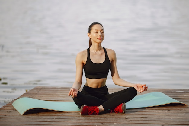 Mujer practicando yoga avanzado por el agua