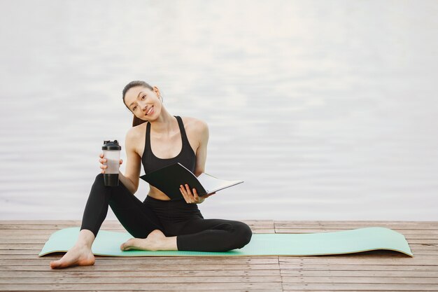 Mujer practicando yoga avanzado por el agua